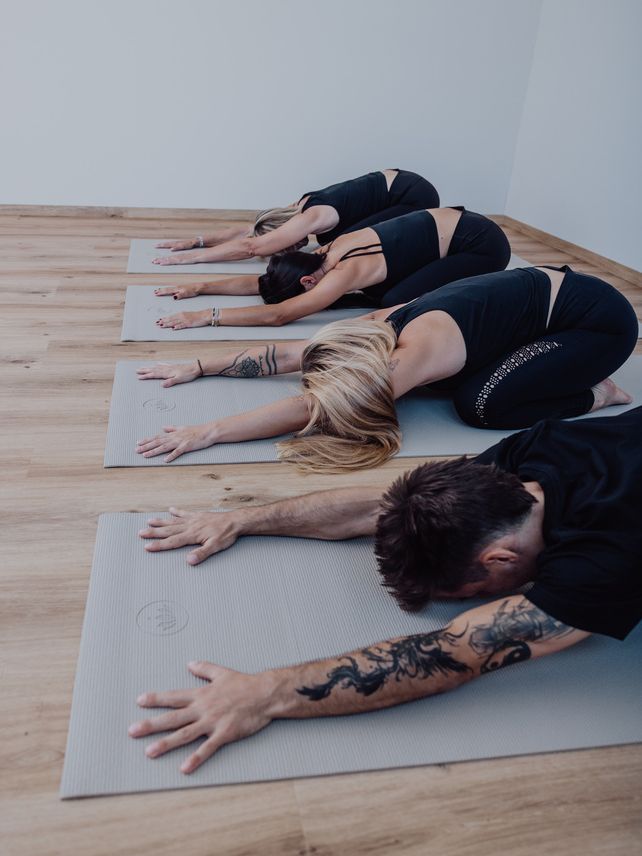 Mehrere Teilnehmende in der Kindhaltung im Kurs Yoga Basics
