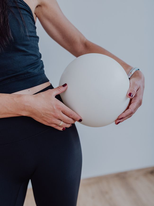 Pilatesball zwischen den Händen im Kurs Yogalates
